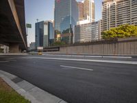 a highway going by a few tall buildings and an intersection with orange cones on each side