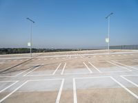 a empty parking lot with the light posts on each side of the empty street area