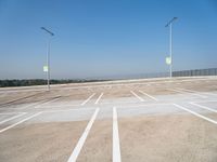 a empty parking lot with the light posts on each side of the empty street area