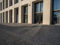 an empty sidewalk near buildings in a city area of europe, in front of blue sky