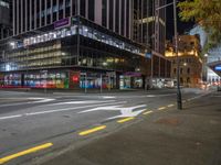 a very large glassy building with a arrow painted on the side of it at night