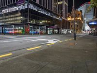 a very large glassy building with a arrow painted on the side of it at night