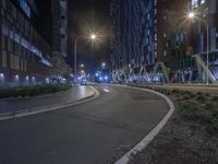 a empty road surrounded by tall buildings at night time in the city of a city