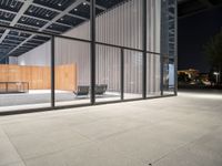 a room with a fence and windows at night on a city street, with modern design