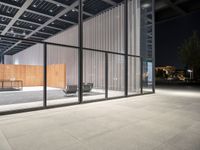 a room with a fence and windows at night on a city street, with modern design