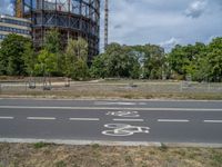 there is an empty street in front of a huge building under construction with trees around