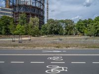 there is an empty street in front of a huge building under construction with trees around