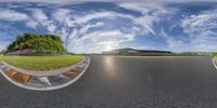 360 view of a street, grass field and red brick barriers with the sky in the background