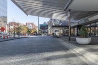 a view of a brick walkway from the street corner of a modern building area, along a sidewalk