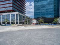 the skateboarder is riding in the large empty area by the building and tree