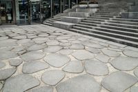 this is a very modern looking area with stone stairs and some concrete steps on the side of the building