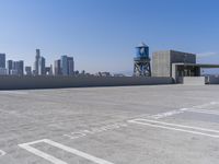 a city with tall buildings is shown in the background and on the ground, there are cars parked on the road