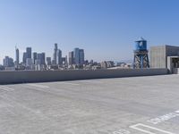 a city with tall buildings is shown in the background and on the ground, there are cars parked on the road