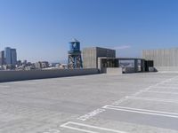 a city with tall buildings is shown in the background and on the ground, there are cars parked on the road