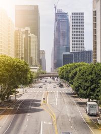 a city street filled with cars and tall buildings in the sun lights on a busy, urban area