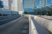 a highway leading to a tall glass structure and buildings in the distance, with one road empty except for vehicles