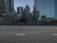 a street is shown with skyscrapers reflected in the glass buildings behind it and a small red fire hydrant in front