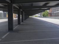 a empty parking lot with two sets of poles next to the street and some buildings behind it