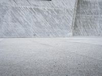 a man riding a skateboard on a cement surface near a ramp with other people