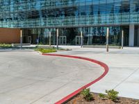 two grey blocks sitting next to a tall building on a sidewalk in front of grass