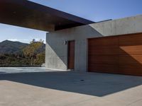 a gray concrete building with stairs and door at the top of the floor next to it is steps leading down to the doorway