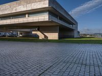 the modern building stands on one side and two smaller buildings can be seen at the other