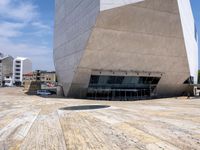 a tall gray building with glass and cement on the outside of it's sides