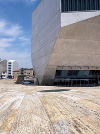 a tall gray building with glass and cement on the outside of it's sides