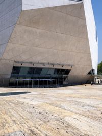 a tall gray building with glass and cement on the outside of it's sides