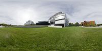 there is a view of a very large building with grass outside of it and a person sitting down on the bench