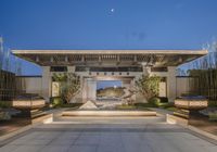 large modern courtyard with water feature at dusk with blue sky and mountains in the background