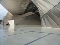 a very large modern building with an unusual curved design, with no people inside it