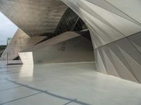 a very large modern building with an unusual curved design, with no people inside it