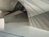 a very large modern building with an unusual curved design, with no people inside it