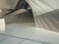 a very large modern building with an unusual curved design, with no people inside it