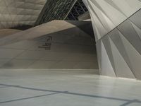 a very large modern building with an unusual curved design, with no people inside it