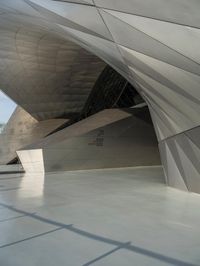 a very large modern building with an unusual curved design, with no people inside it