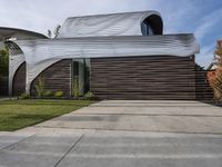 the home's exterior is a modern, curving, patterned structure with an open roof