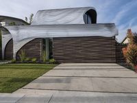 the home's exterior is a modern, curving, patterned structure with an open roof