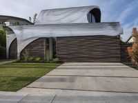 the home's exterior is a modern, curving, patterned structure with an open roof