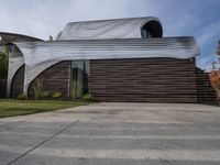 the home's exterior is a modern, curving, patterned structure with an open roof