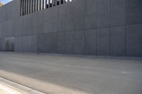 a person wearing a face mask walking across an empty street with a skateboard in the foreground