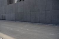 a person wearing a face mask walking across an empty street with a skateboard in the foreground