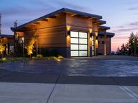 a beautiful modern garage with its large sliding door in the evening time sunlight and dusk sky