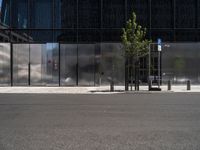 a city street has a bench on it near a modern glass building and street signs