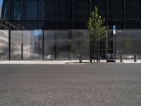 a city street has a bench on it near a modern glass building and street signs