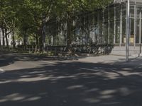 a large glass building with a person walking in front of it on a street in the middle of the day