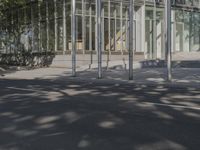 a large glass building with a person walking in front of it on a street in the middle of the day