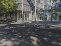 a large glass building with a person walking in front of it on a street in the middle of the day
