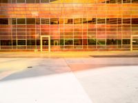 large modern glass and metal building with a red, yellow, orange, and black front and sides